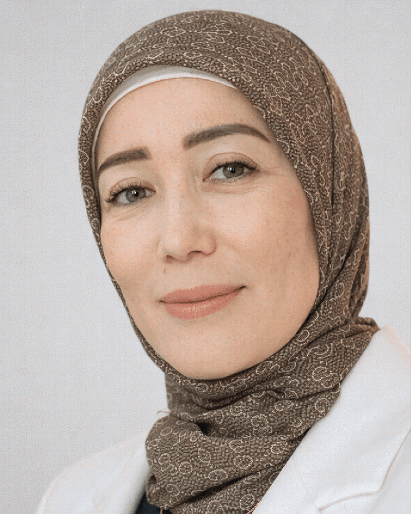 Professional photo of Uzbek woman in her 30s with long dark hair wearing white blouse smiling confidently in modern office environment
